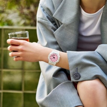 Una mujer que viste un blazer gris de gran tamaño lleva puesto en la muñeca el reloj de pulsera G-SHOCK GMA-P2100SR-7AER.