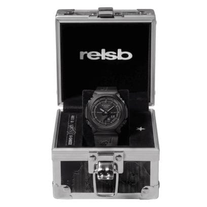 El embalaje del reloj de pulsera GM-S2110B-8ARLSB, en colaboración con Rels B, es una pequeña caja negra y plateada con el logotipo de Rels B en el interior de la tapa.