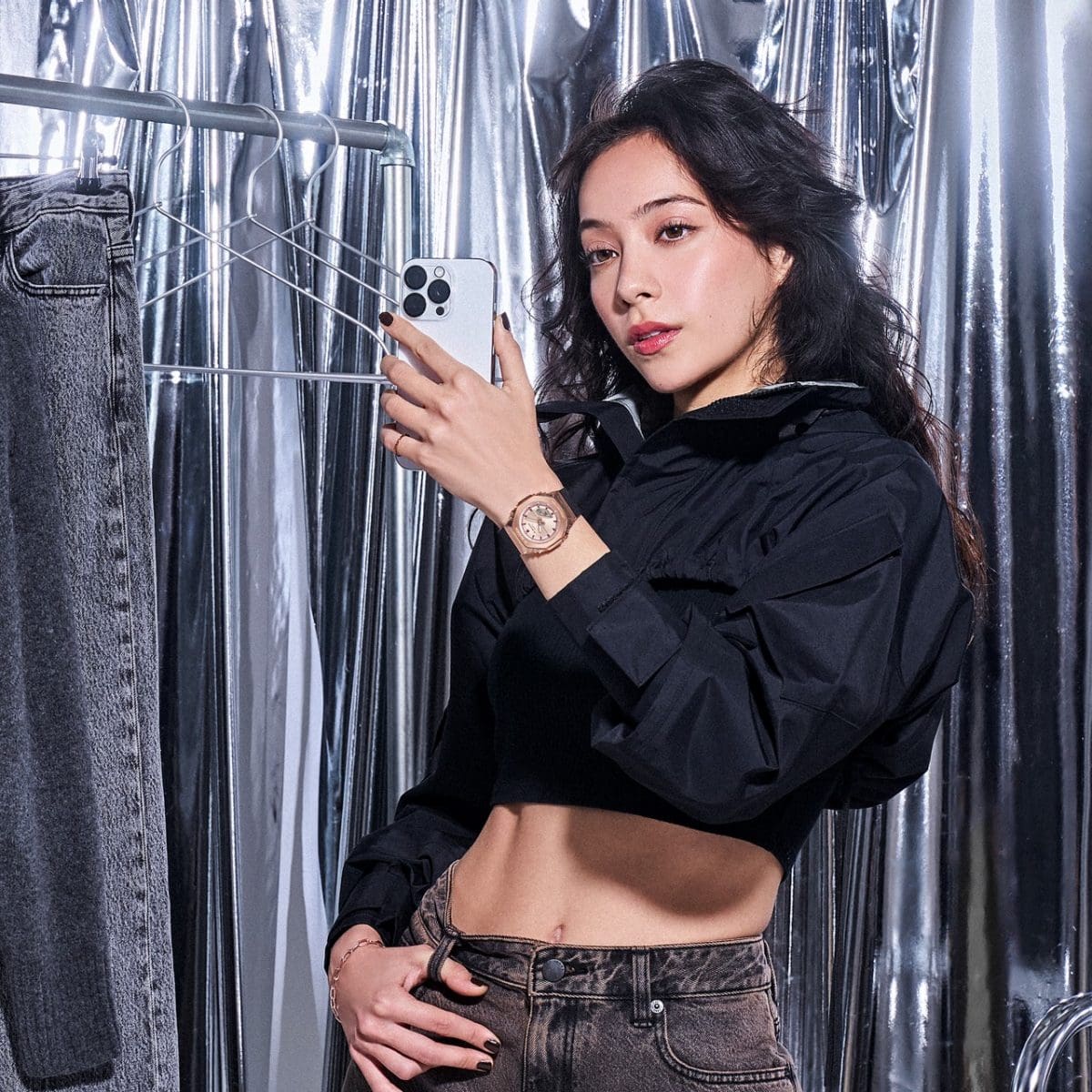 Una mujer de cabello negro y sudadera con capucha negra se toma una selfie, se puede ver el G-SHOCK GM-S2110PG-1A4 en su muñeca