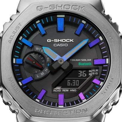 Detalle de la pantalla analógico-digital negra del reloj de pulsera GM-B2100PC-1A con detalles en varios tonos de morado