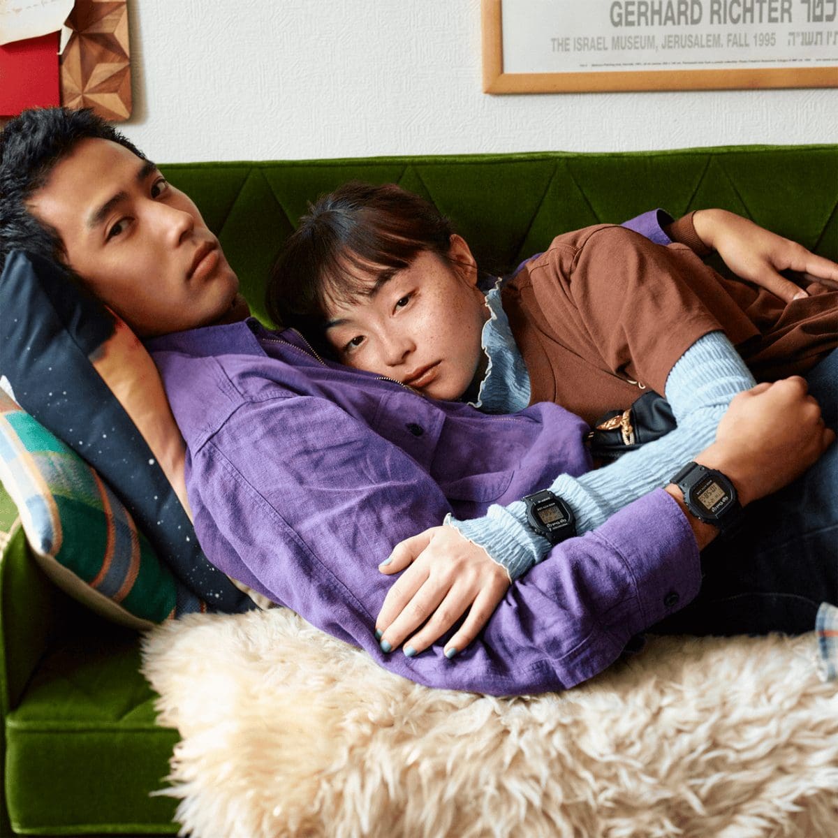 Dos personas están tumbadas en un sofá con un pelaje abrazable y cada una lleva un modelo de la Lovers Collection en las muñecas
