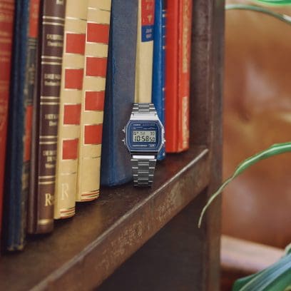 The CASIO VINTAGE COLLECTION A158WEA-2EF is sitting on a bookshelf.