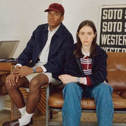 A woman and a man, each wearing a color variant of the A158WEA on their wrist, sit next to each other on a couch.