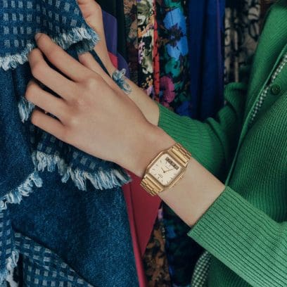 The CASIO Vintage Collection watch "AQ-230A-7AMQY" with golden band and analogue display on a women's wrist looking for clothes.