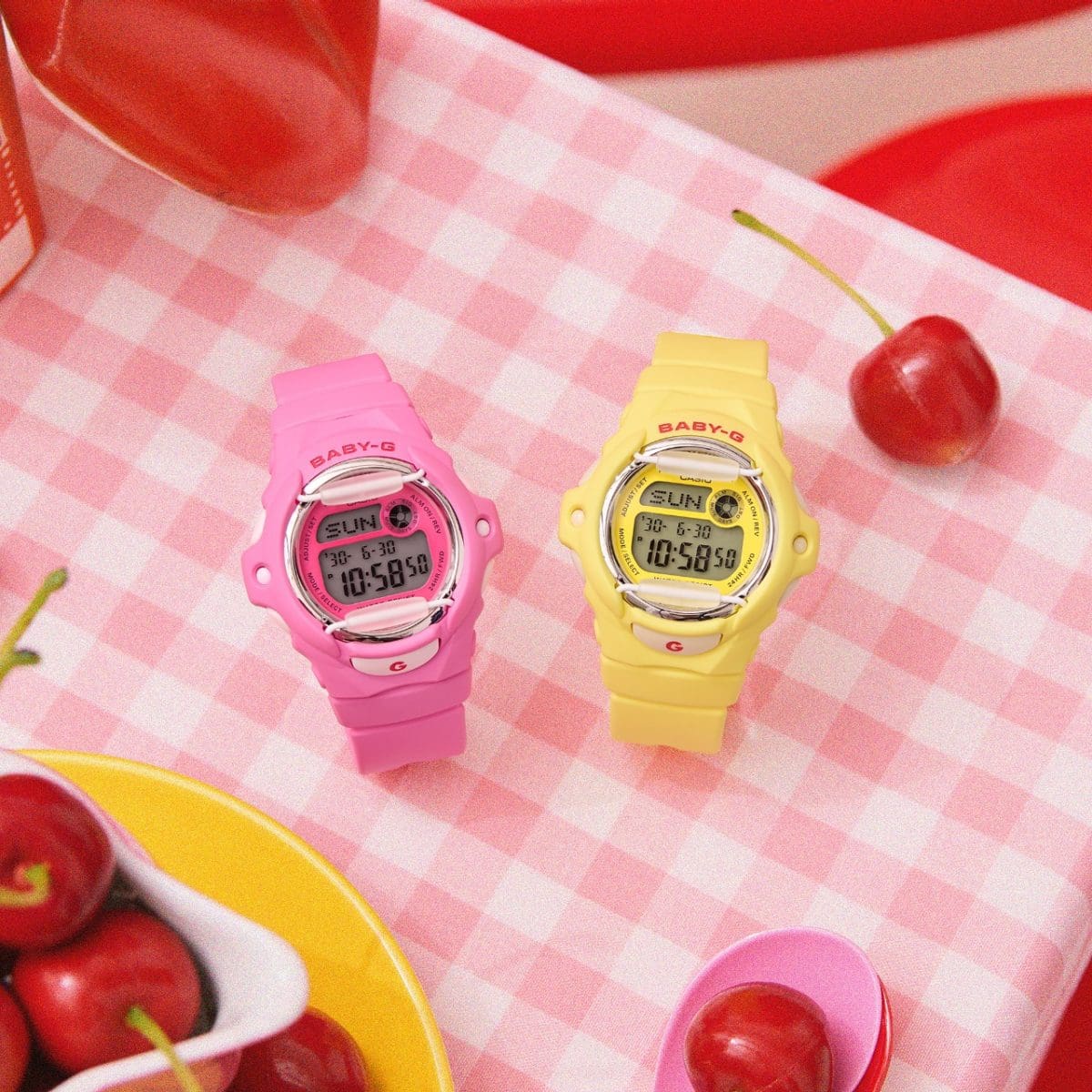 The pink and yellow models of the "Cherry on Top" series on a pink and white checkered tablecloth.