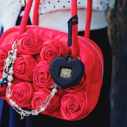 The BGD-10KH-2CER in its heart-shaped case hangs from a red handbag.