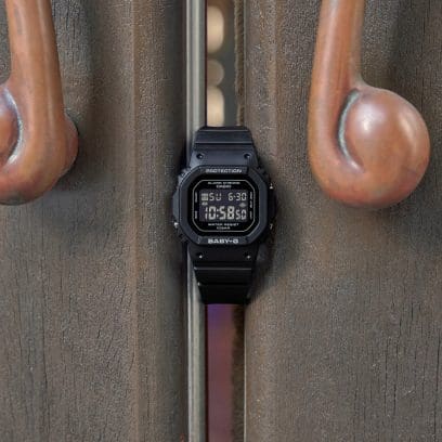 The BGD-565U-1ER between two curved metal handles against a rough, industrial surface. 