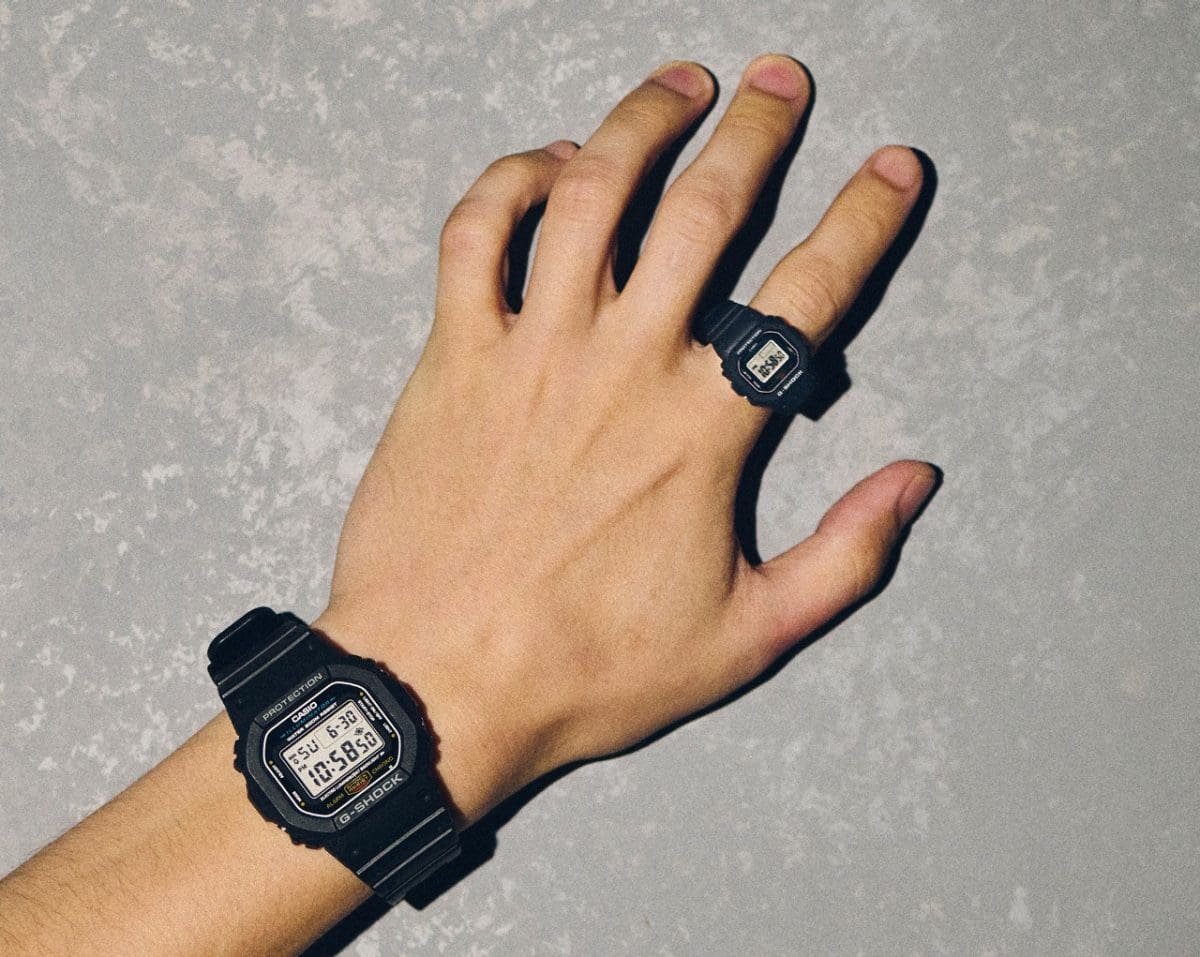 A person wears the DWN-5600-1ER on the ring finger and the classic DW-5600UE-1 on the wrist