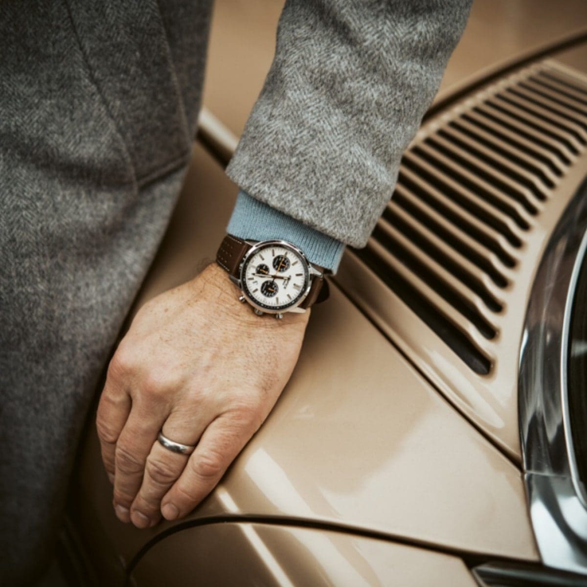 Close-Up of the EDIFICE EFR-575L-7A watch on the wrist of a man leaning on a beige car bonnet