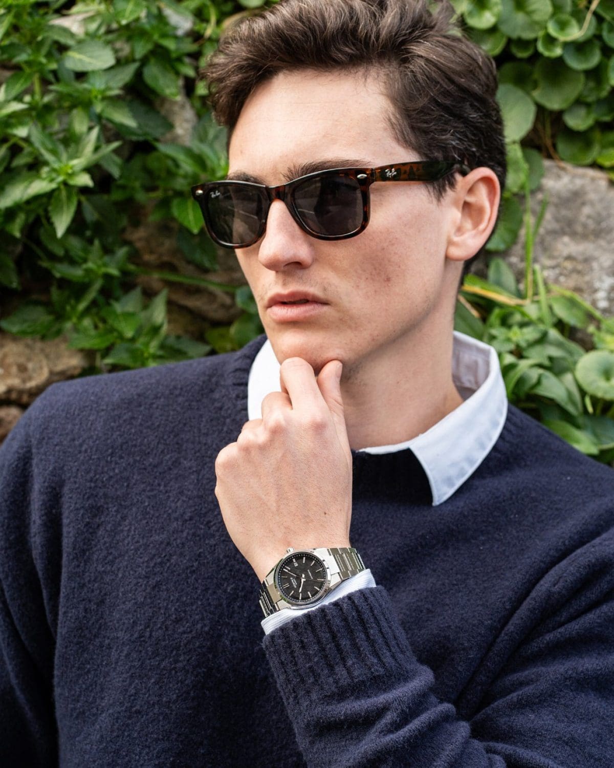 A man wearing a dark blue wool sweater and black sunglasses is wearing the analog EFK-110D-1A on his wrist