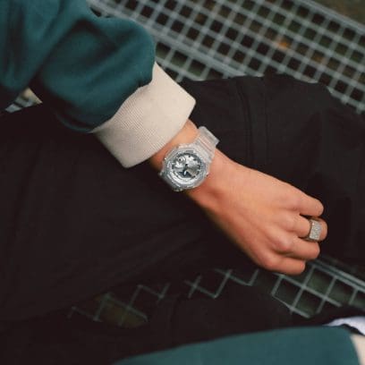 Close-up of the GA-2100BM-7A8 on the wrist. The watch is worn in combination with a green and beige sweater.