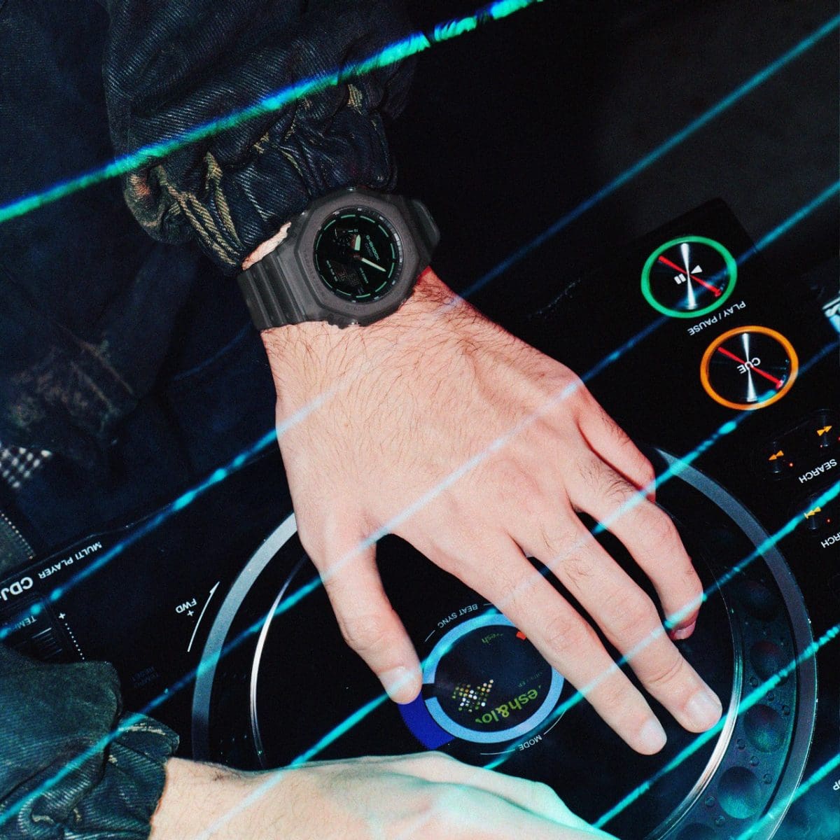 The black GA-2100K-1AER on the wrist of a man operating a mixing console.