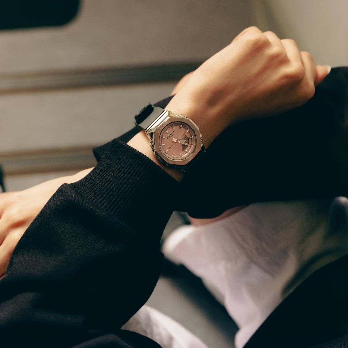 Close-up of the GM-S2110-4AER on a woman's left wrist. She is wearing the watch with a black sweatshirt.