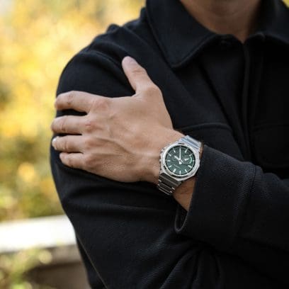 A man wearing a black jacket is wearing the GST-B1000D-3AER on his wrist
