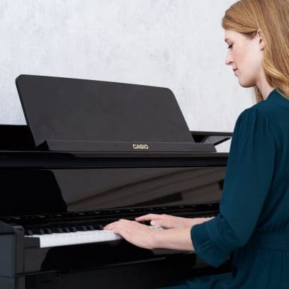 Une femme est assise devant le CELVIANO Grand Hybrid GP-510BP noir brillant.