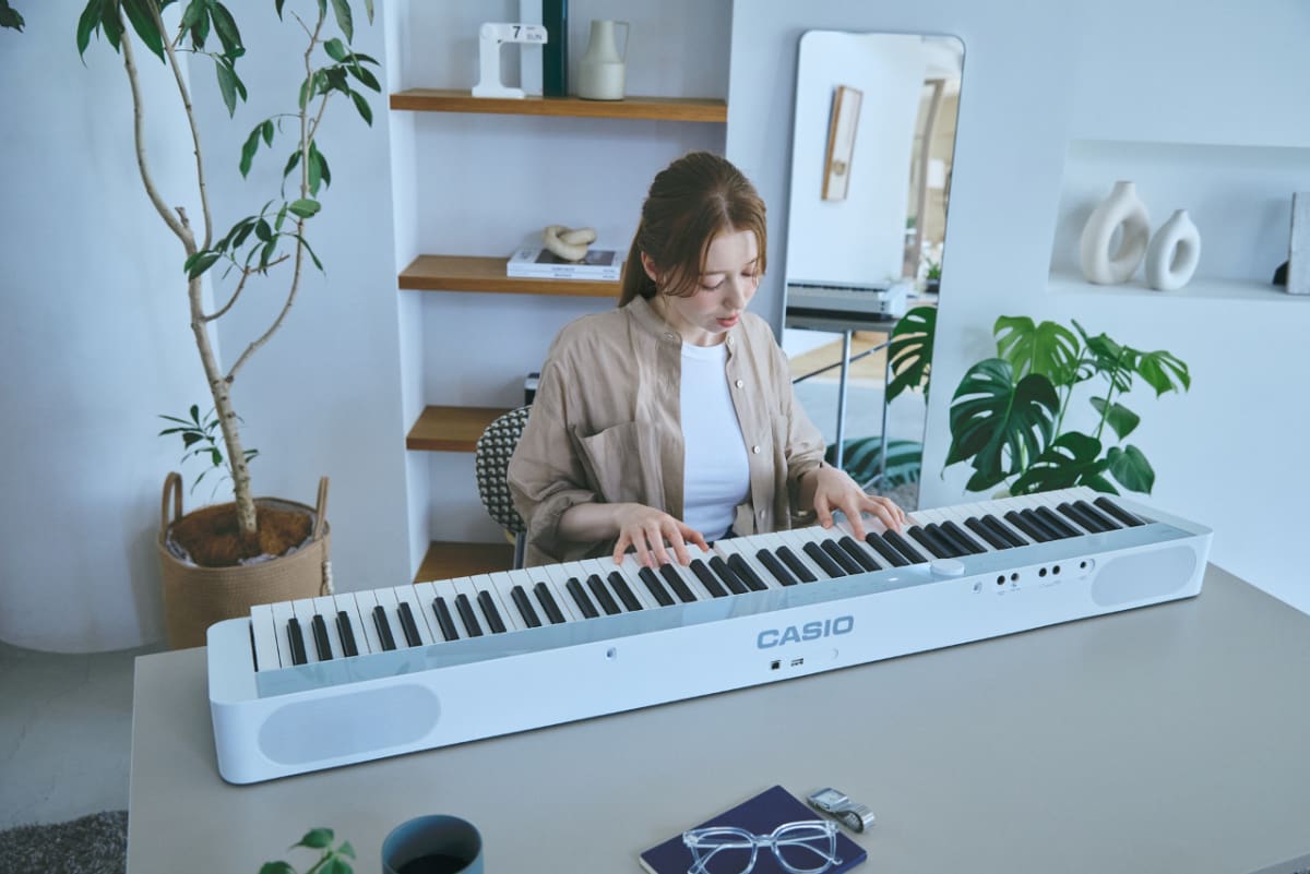 Une femme joue sur le piano numérique CASIO Privia PX-S1100 - photo lifestyle.