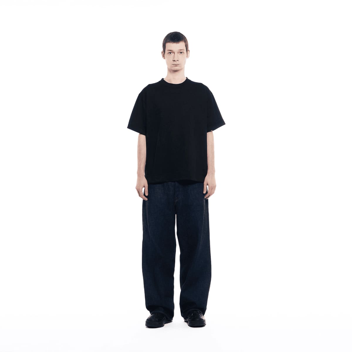 Un homme portant un jean foncé porte le t-shirt GXFAB.