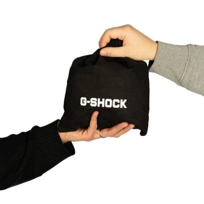 Vue de face du sac cadeau G-SHOCK à plat, avec cordon de serrage noir.