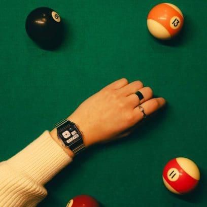 Une femme porte le A130WE-1A et a posé son bras sur une table de billard