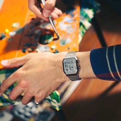 Gros plan sur le poignet d'un homme portant la montre numérique A130WE au poignet et utilisant une palette de couleurs.