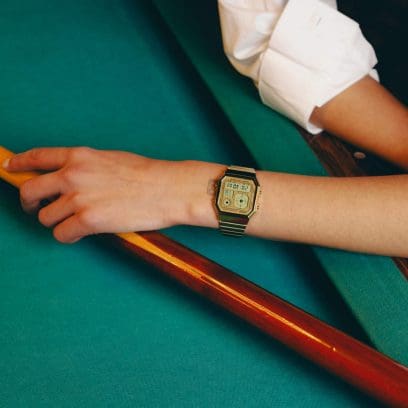 Une femme portant l'A130WEG-9AEF et a posé son bras sur une table de billard