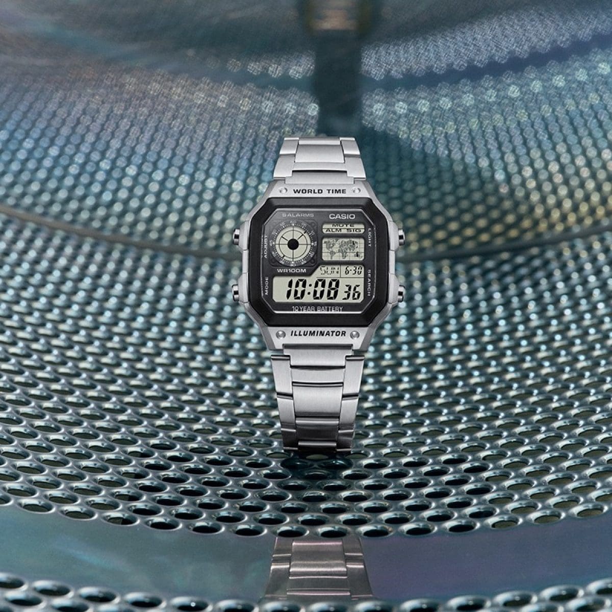 Photo de la montre CASIO AE-1200WHD-1AV sur une surface métallique dans une laverie automatique.