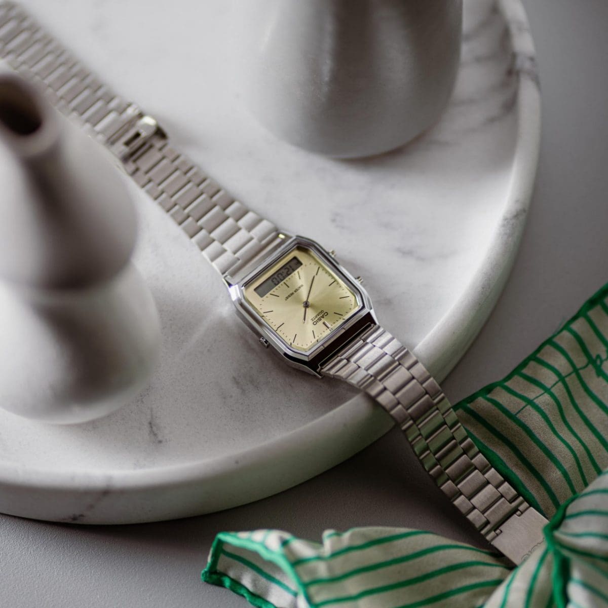La montre AQ-230A-9AMQYES est posée sur un plateau de marbre et une table claire.