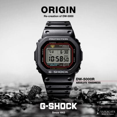 Image de campagne de la montre G-SHOCK DW-5000R-1A : la montre sur un sol pierreux, à côté de laquelle on peut voir l'inscription « DW-5000R Absolute toughness ».