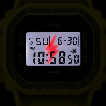Gros plan de l'écran DWE-5600JB-1A9 dans l'obscurité avec l'éclairage LED allumé. Le flash caractéristique est visible en rougeâtre en arrière-plan.