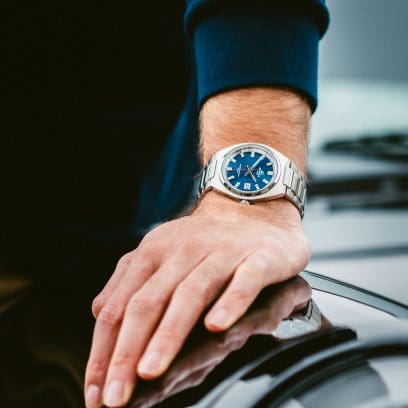 L'EFB-109D-2AVEF au poignet d'un homme appuyé sur le capot d'une voiture