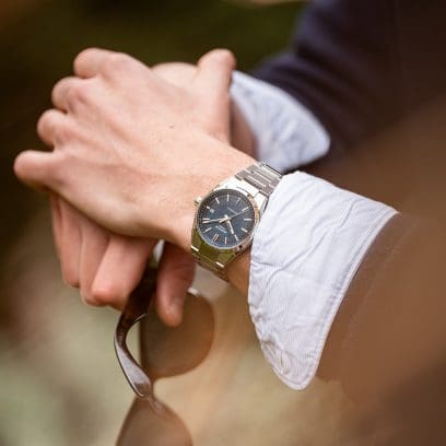 Un homme porte le bracelet EFK-110D-2A et tient des lunettes de soleil à la main