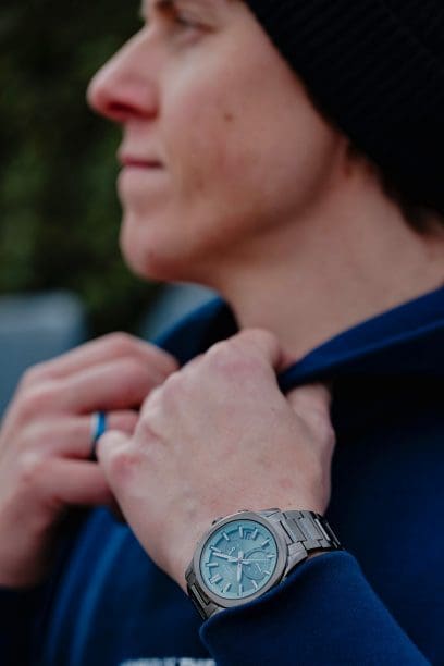 Un homme portant un haut bleu et une casquette porte la montre-bracelet EDIFICE EQB-1300DC-3AEF à son poignet.