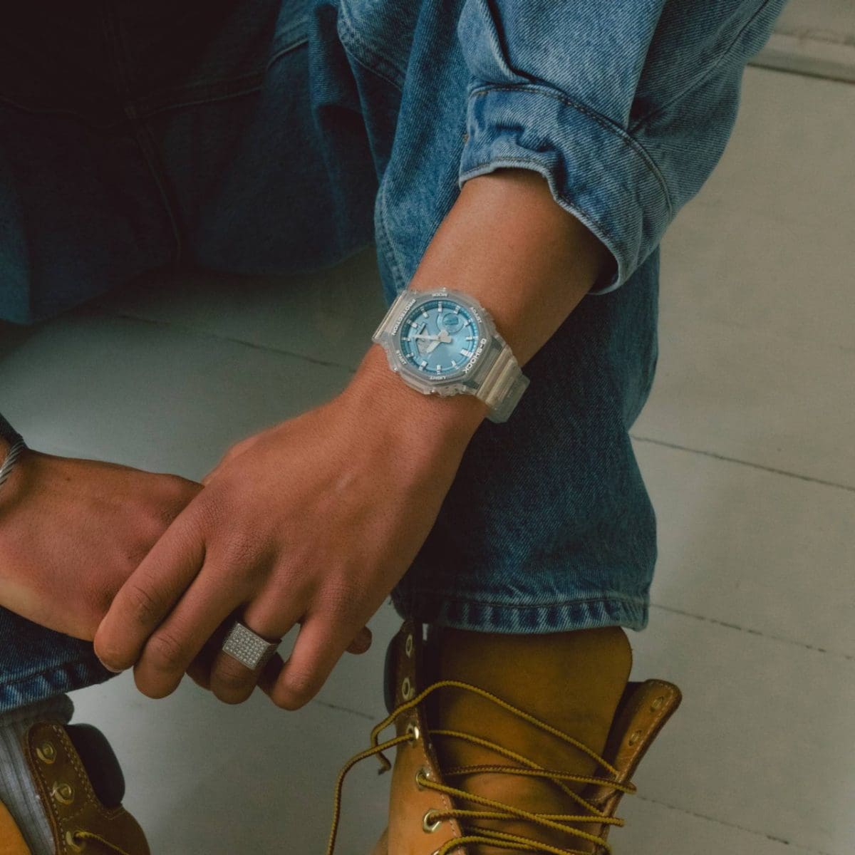 La GA-2100BM-7A2 au poignet d'un homme portant une veste en jean assortie à un pantalon en jean. 