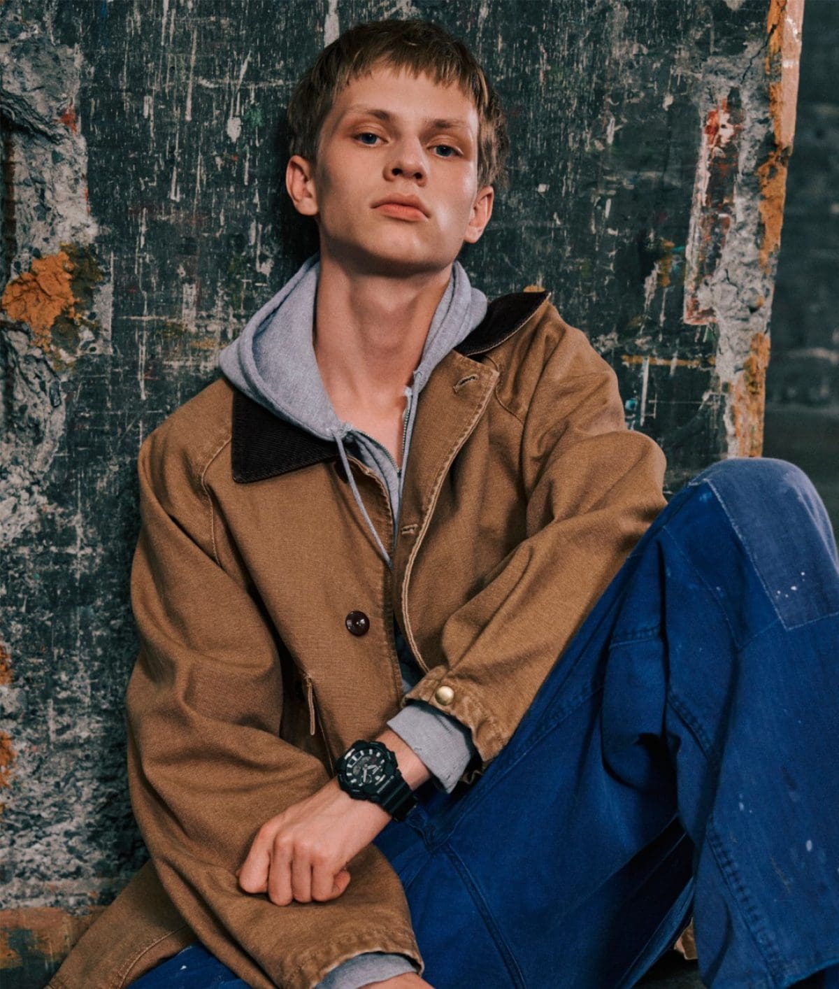 Un homme portant une veste marron clair et un jean bleu porte le GA-B010-1AER à son poignet.