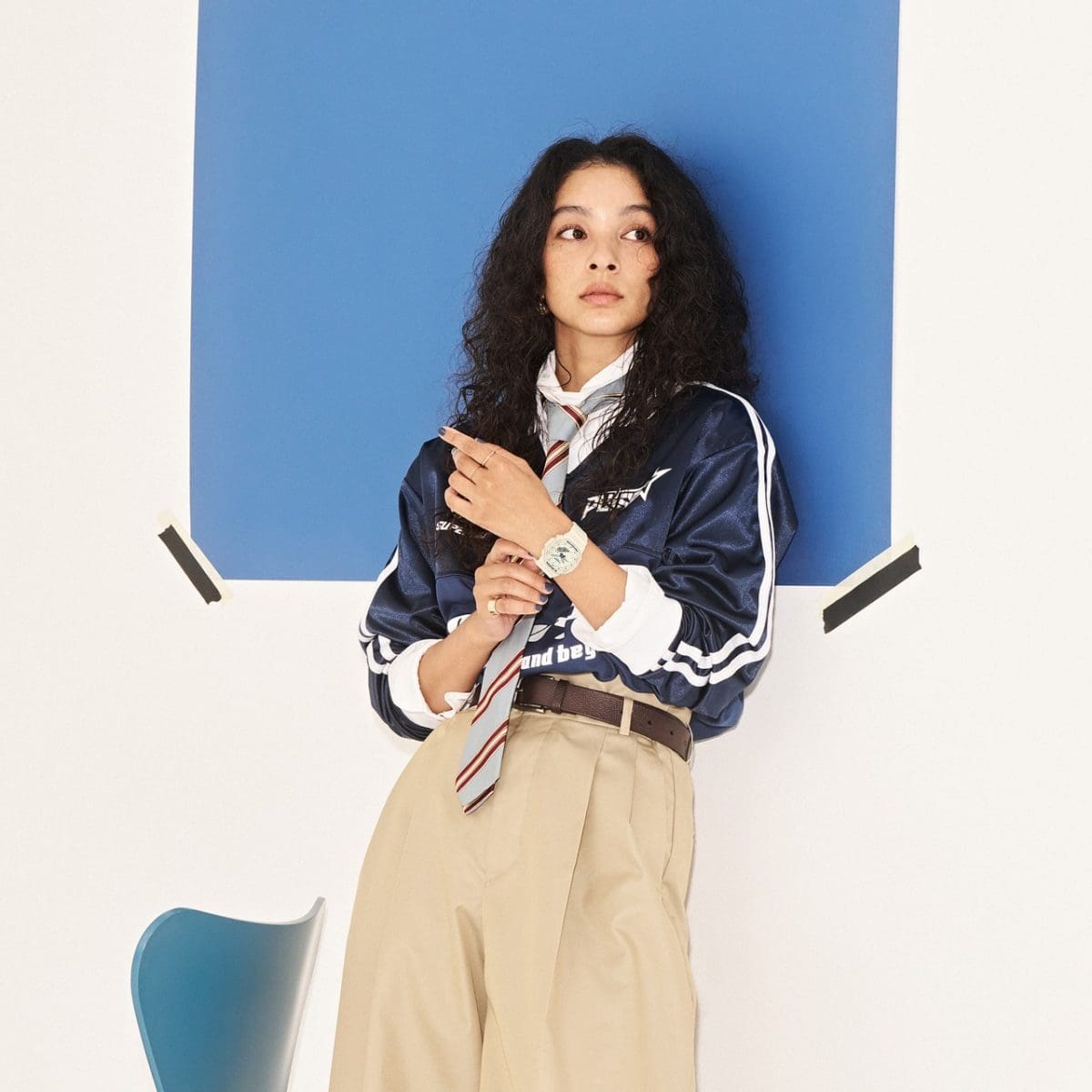 Une femme vêtue d'une tenue de style universitaire porte la montre GMA-P2100BA-7AER à son poignet.