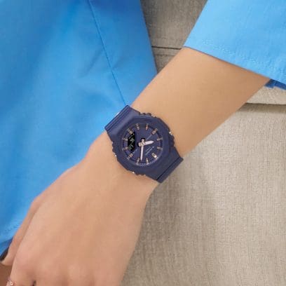 Le GMA-P2100M-2A bleu au poignet d'une femme. Elle porte un haut bleu clair