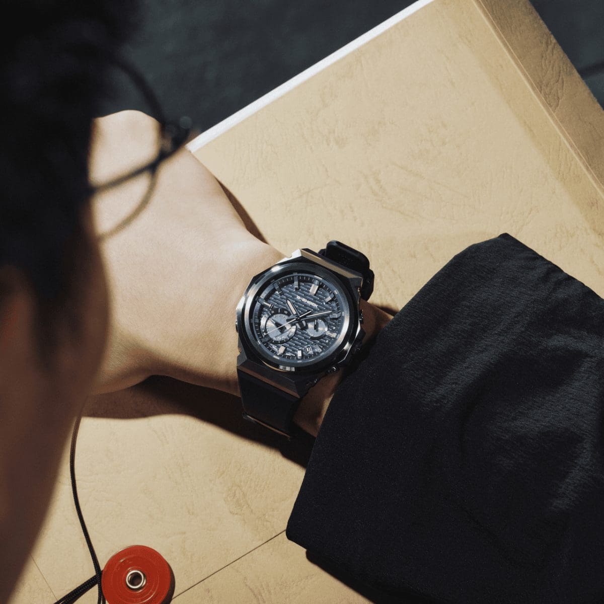 Un homme porte la montre-bracelet G-SHOCK GST-B1000-2AER à son poignet.