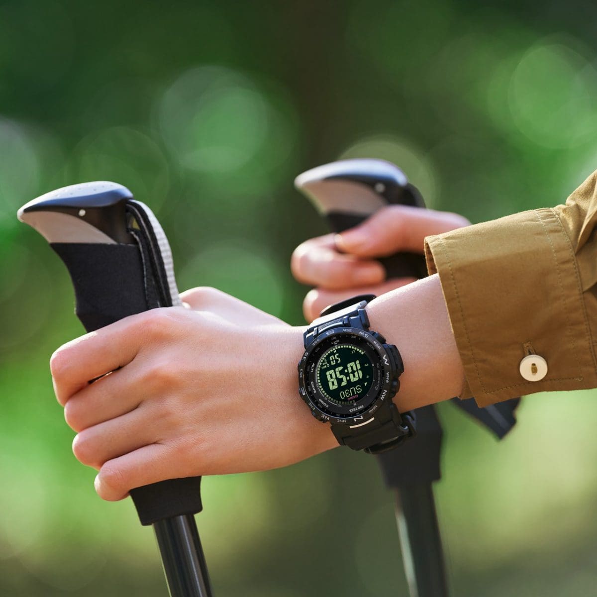 Deux mains sur les poignées de bâtons de marche nordique, au poignet gauche se trouve la montre-bracelet noire PRW-35Y-1B.