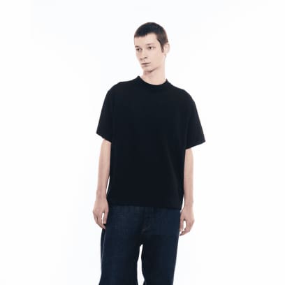 Un uomo con indosso jeans scuri porta la maglietta GXFAB.
