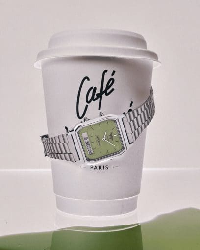 L'orologio da polso argentato AQ-230ECK-3AER con quadrante verde matcha è avvolto attorno a una tazza da caffè da asporto del Café Kitsuné.