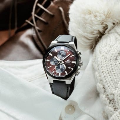 L'EFS-S630BL-5AV è appoggiato su una camicia bianca. Accanto ad esso c'è un cappello di lana e, sullo sfondo, si vedono delle scarpe marroni.