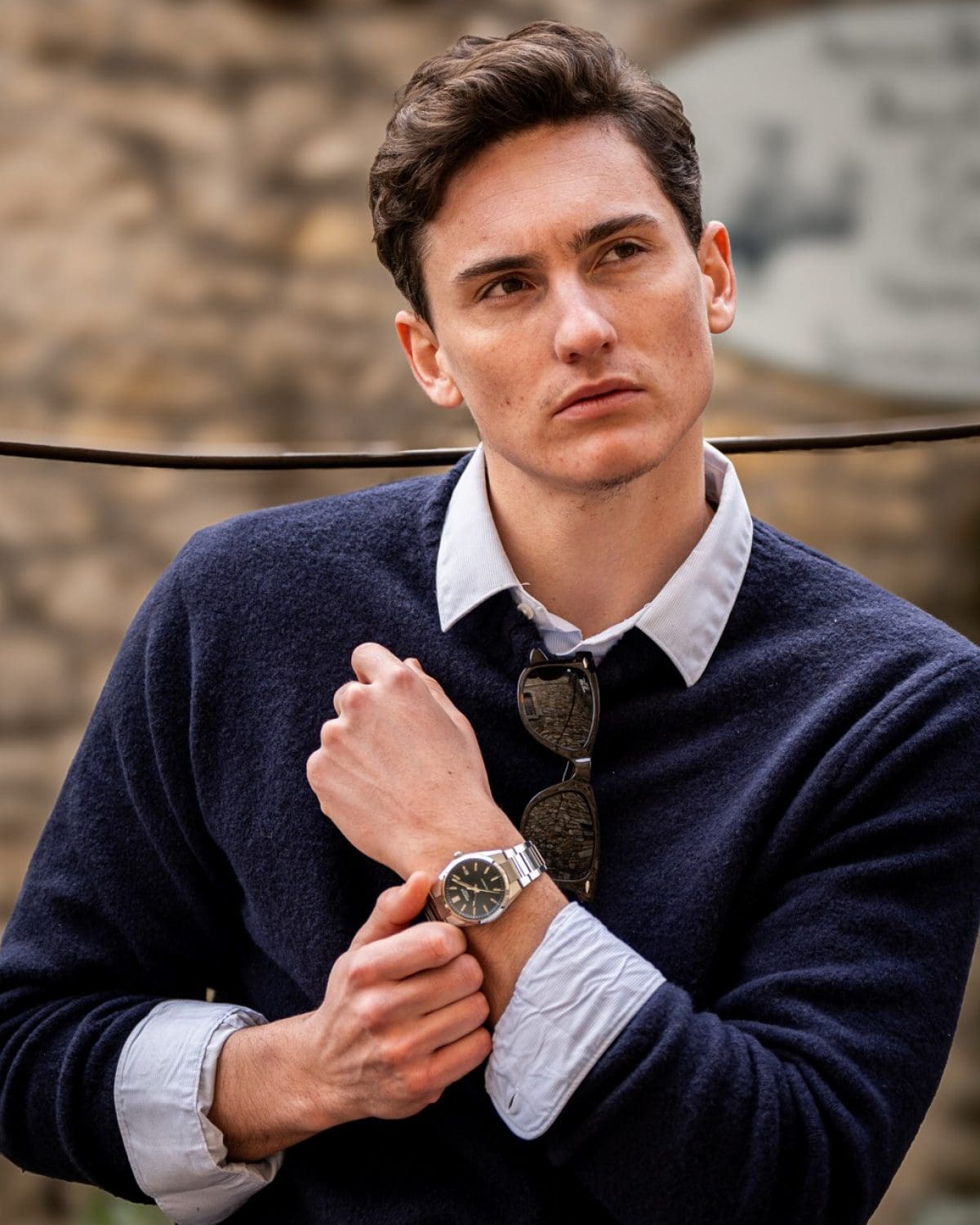 Un uomo che indossa una camicia azzurra e un maglione di lana blu scuro sopra porta al polso l'EFK-110D-2A