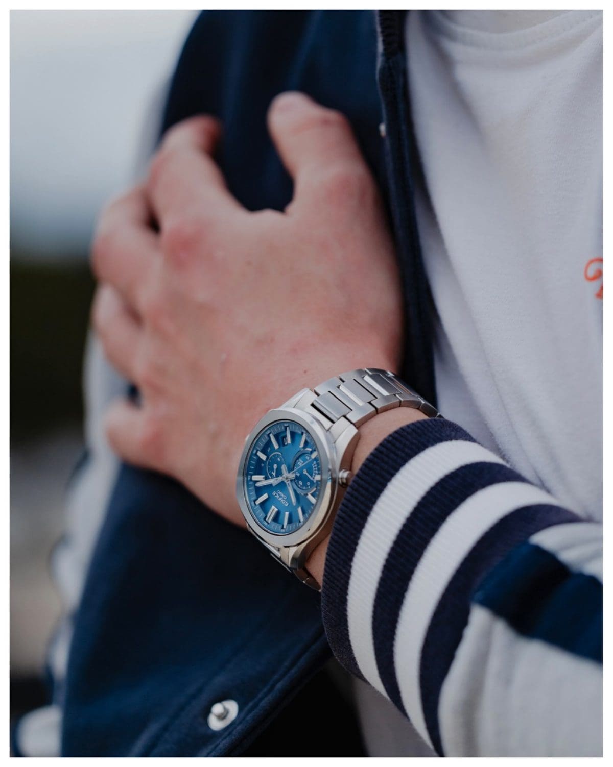 Un uomo indossa una felpa sportiva e al polso l'orologio analogico EDIFICE EQB-1300D-2AEF.