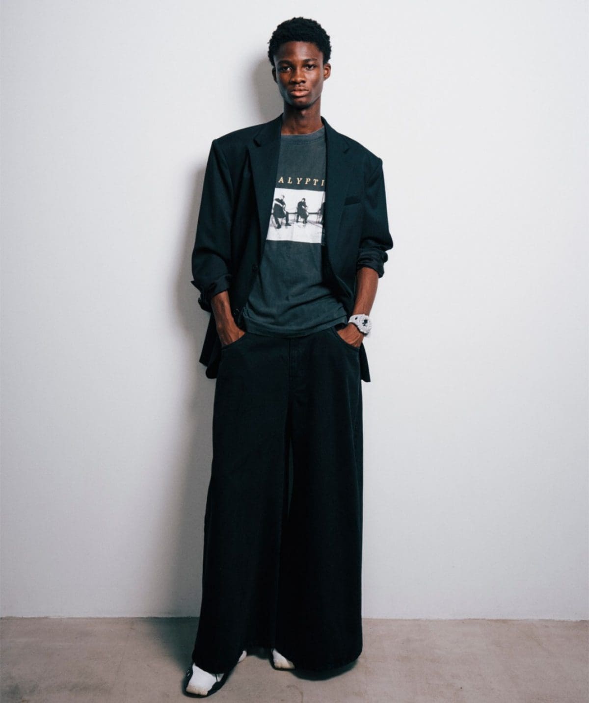 Un uomo dalla pelle scura con abiti neri indossa al polso il modello GA-V01-7AER bianco.