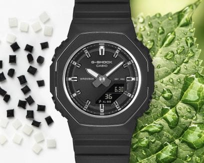 A destra del GMA-P2110-1AER c'è una foglia verde con gocce d'acqua e a sinistra ci sono piccole perle di materiale in resina