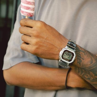 Un uomo indossa il GMW-B5000D-1CER al polso, indossa una maglietta beige e tiene un gelato in mano