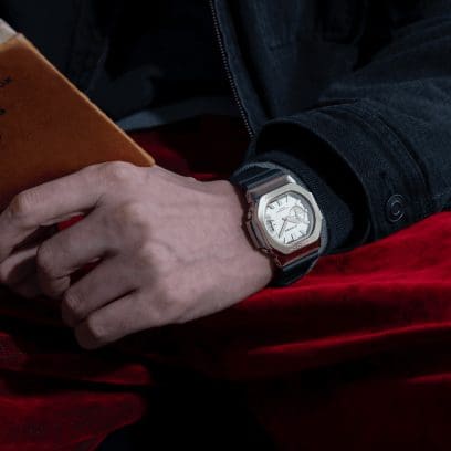 Un uomo con una giacca di jeans scura indossa al polso l'orologio da polso dorato GMC-2500G-9A