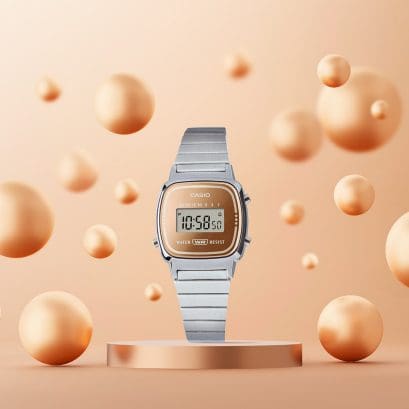 L'orologio da polso LA670WES-4A è posizionato su un piedistallo, mentre a sinistra e a destra volano in aria sfere di colore bronzo di diverse dimensioni.