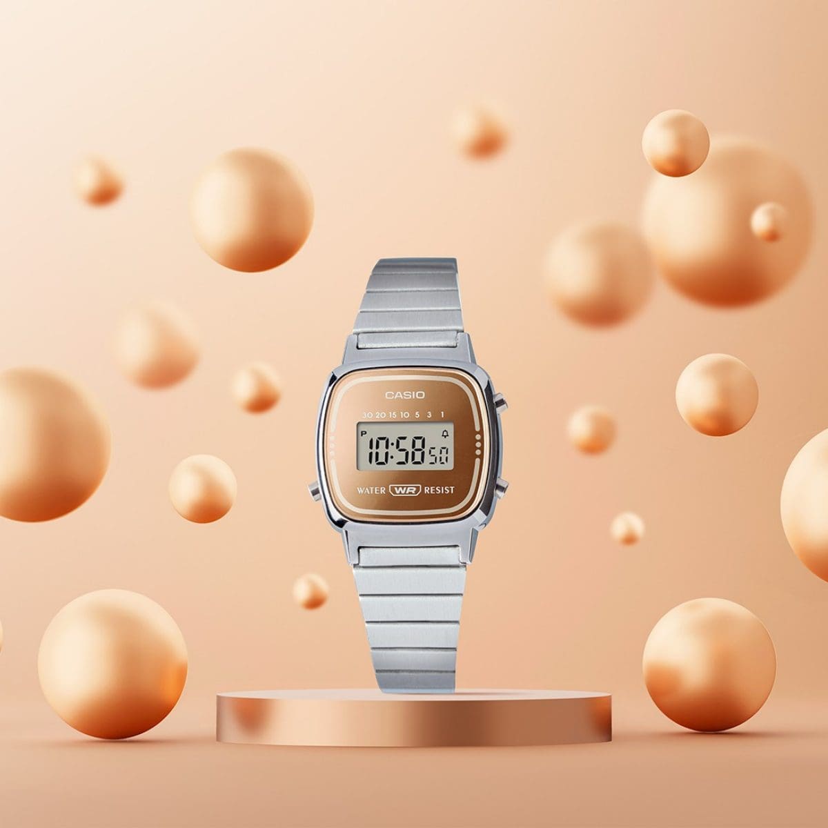 L'orologio da polso LA670WES-4A è posizionato su un piedistallo, mentre a sinistra e a destra volano in aria sfere di colore bronzo di diverse dimensioni.