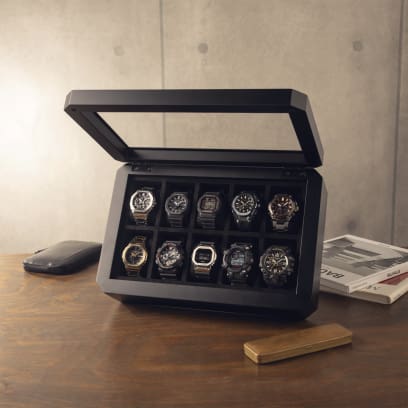 De horlogebox is gevuld met 10 verschillende horloges en staat op een bureau